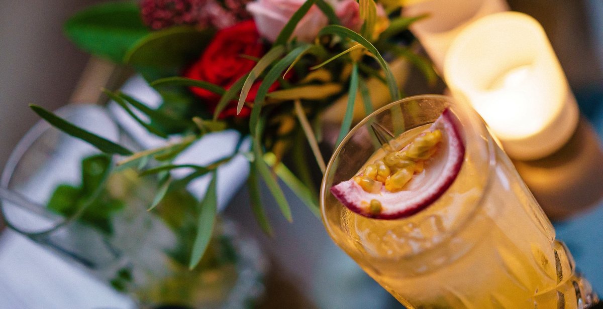 Cocktails on a table with flowers and a candle